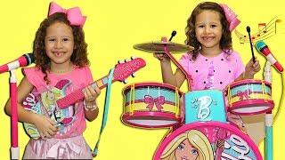 Valentina plays with a toy battery and Disney guitar  and starts a band complete