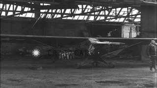 Pilot loads rocket launcher on United States Piper L-4 Grasshopper aircraft at an...HD Stock Footage