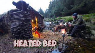 Bushcraft camp by a river with a heated bed