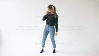 Young woman with headphones listening music and dancing on white studio indoors