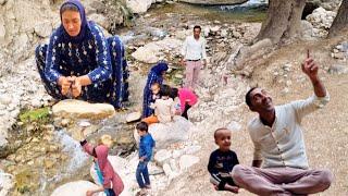 Dariush, Zahra, and the children go to the waterfall and play with the water