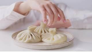 A Person Touching Dumplings on a Plate