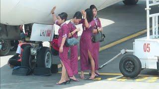 Pramugari Lion Air berteduh di Bawa Pesawat Menunggu Penumpang Turun di Bandara Ngurah Rai Bali