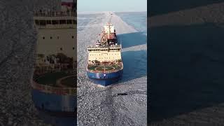 Icebreaker ship clearing icy water for other cargo ships