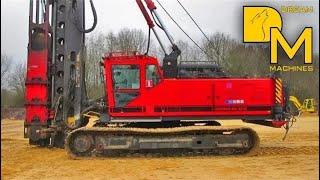 PILE DRIVER MACHINE WITH IMPACT HAMMER ERECTING CONCRETE FOUNDATIONS