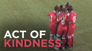 Opponents huddle around soccer player after hijab comes loose during match