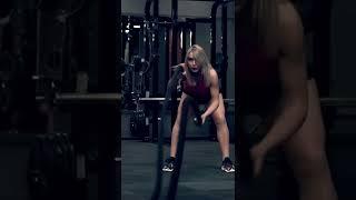 Muscular woman in a red top working out in the gym lifting weights #shorts #fitness #womenfitness