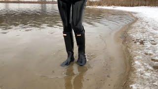 Winter water walking in rubber boots and latex