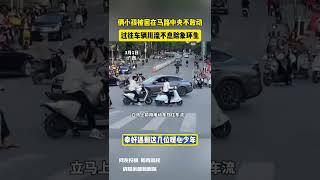 俩小孩被困在马路中央不敢动 过往车辆川流不息险象环生 幸好遇到这几位暖心少年