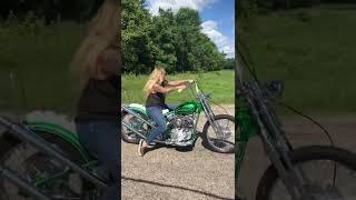 Biker girl rolling on her classic Harley-Davidson chopper motorcycle