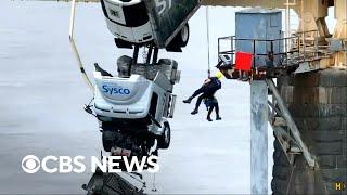 Driver rescued from tractor-trailer dangling over the edge of bridge