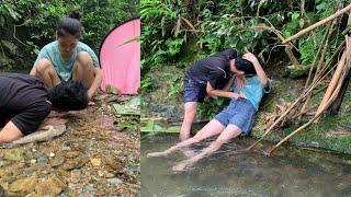 Couple using net to catch stream fish, Camping Cooking in the forest, survival skills