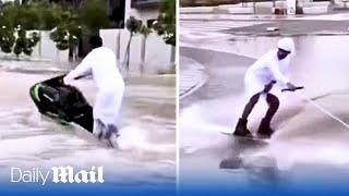 Thrill seeking Emiratis on jet skis swerve through Dubai's flooded roads after heavy rains sink cars