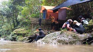 People camping in the forest in heavy rain built boat shelters on rocks on the river bank