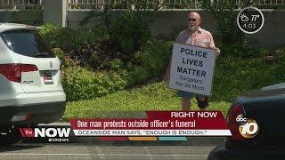 Man explains reason for standing outside officer's funeral with sign