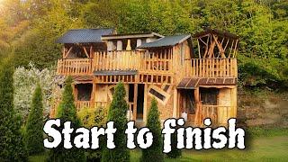 Construction of a two-story house near the waterfall. Working alone