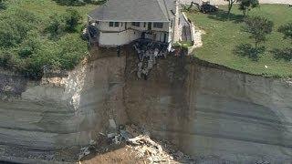 Couple looks on as house falls off cliff