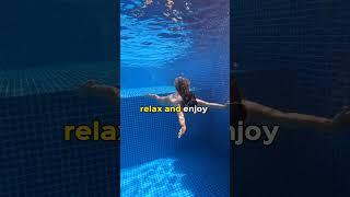 Girl swims underwater in pool