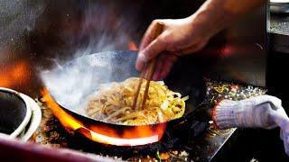 Chinese street food flame egg fried rice, fried noodles Char Koey Teow at the roadside night market