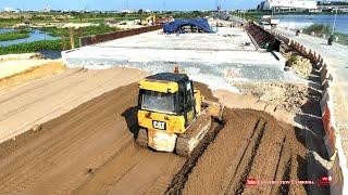 Perfectly CAT D3K bulldzer pushing soil sand making base foundation connected of the bridge