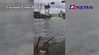 Airboats and trucks travel against floodwaters in Vidor