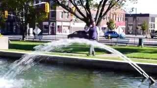 Guy falls in fountain while on cell phone