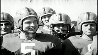 Terry Brennan with the Notre Dame Fighting Irish football team players on a field...HD Stock Footage