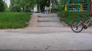 Three years old boy riding running bike down the stairs