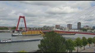 Te hoog beladen binnenvaartschip vaart tegen Willemsbrug; containers in het water