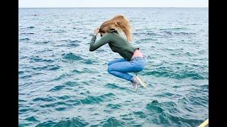 funny girl in dry clothes jumps from breakwater and her clothes get wet for wetlook video