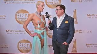 Laura X Desiree of Naked News is interviewed on the red carpet at the 2019 Xbiz Awards