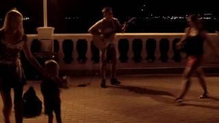Прикольный уличный гитарист круто играет на набережной на Черном море в Геленджике на день города