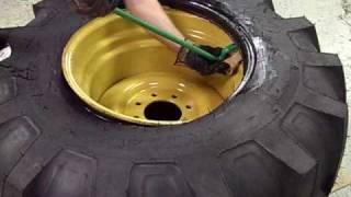 Ken-Tool: 21L-24 Backhoe Tire Being Dismounted Using Super Serpent™ Tire Tool (#35448)