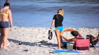 Man smells or licks something off womans butt at Myrtle Beach SC . What do you think he was doing ?