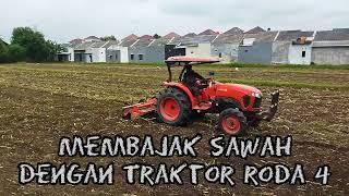 Membajak sawah dengan traktor roda 4