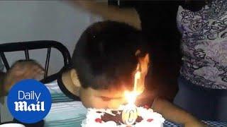 Moment boys hair goes up in flames as he eats birthday cake