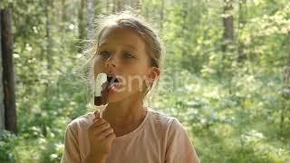 Kid Licking Ice-Cream. Charming Child Eats Ice Cream Outside. Little girl licking ice-cream. | S...