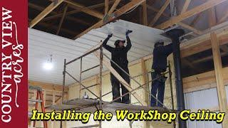 Using a rolling scaffold to install the 14 foot high metal Ceiling in the new workshop.