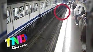 Woman distracted by mobile phone falls onto subway tracks