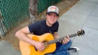 Ben Kasica playing guitar on the sidewalk