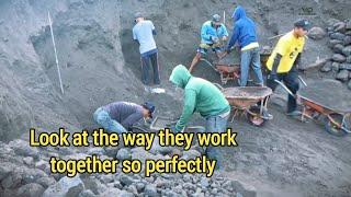 See how they work together to find the black sand and load it into the truck