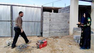 Installing a yard door for Sakineh's house by a welder