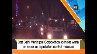 East Delhi Municipal Corporation sprinkles water on roads as a pollution control measure