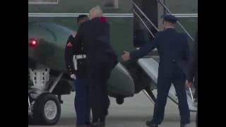 President Trump Picks Up A Marine's Hat After The Wind Knocks It Off