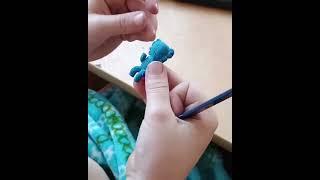 7 year old sculpting a kaws companion figure with modelling clay