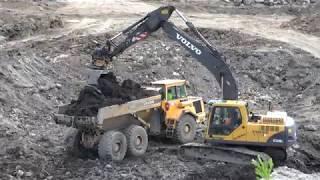 Landfill waste at landfill Volvo 210B excavator