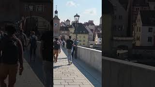 On a famous bridge, an unknown musician almost always performs. The Old Stone Bridge, Regensburg.