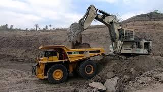 EXCAVATOR RAKSASA MEMUAT MATERIAL TAMBANG KE DUMP TRUCK RAKSASA