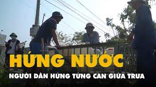 Giữa trưa nắng chói chang, người dân Gò Công Đông đi hứng từng can nước