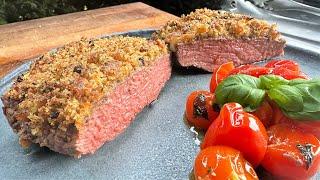 Beef rump steak with cheese crust on melted tomatoes